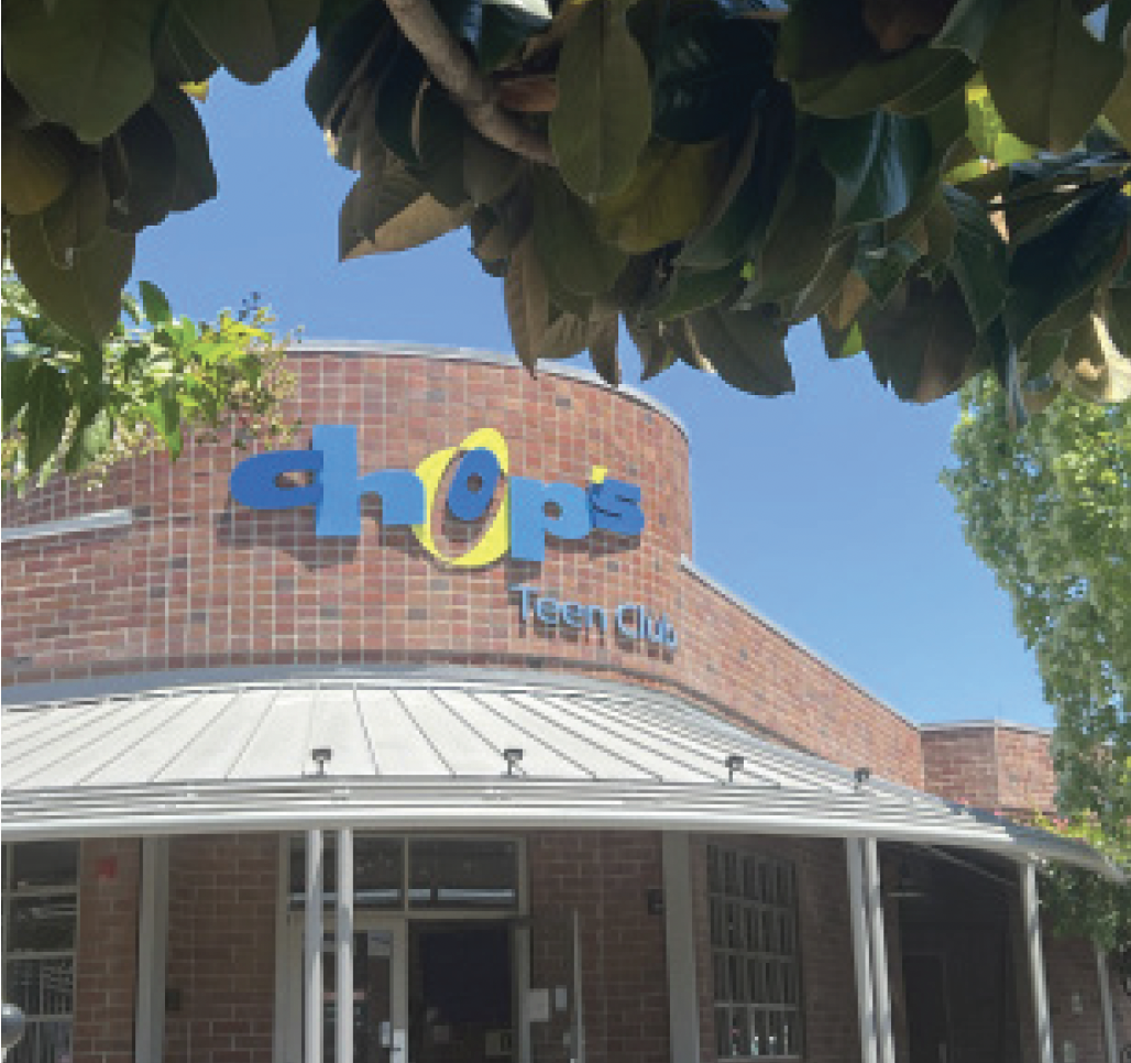 Brick building with a sign reading "Chop's Teen Club." Tree branches frame the top of the image.